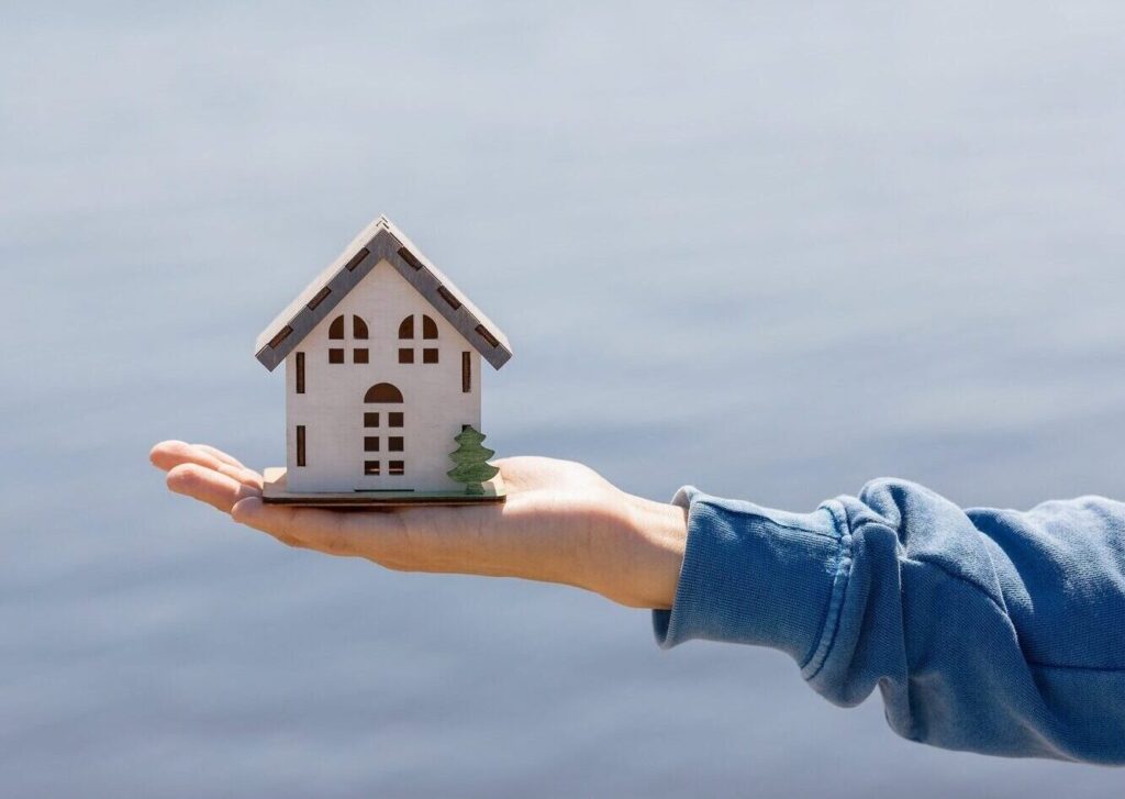 buying or selling real estate, woman holding a miniature or model of a house in her hands