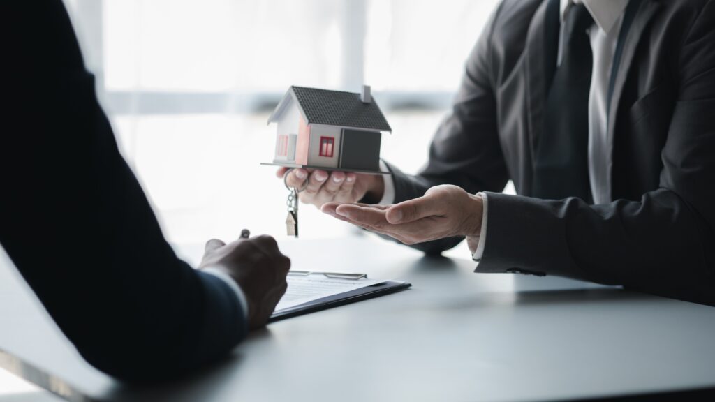 Real estate agents are holding a housing model.