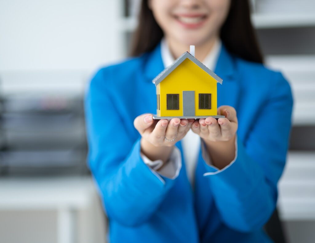 Real estate house agent showing house model to customer, real estate housing concept.