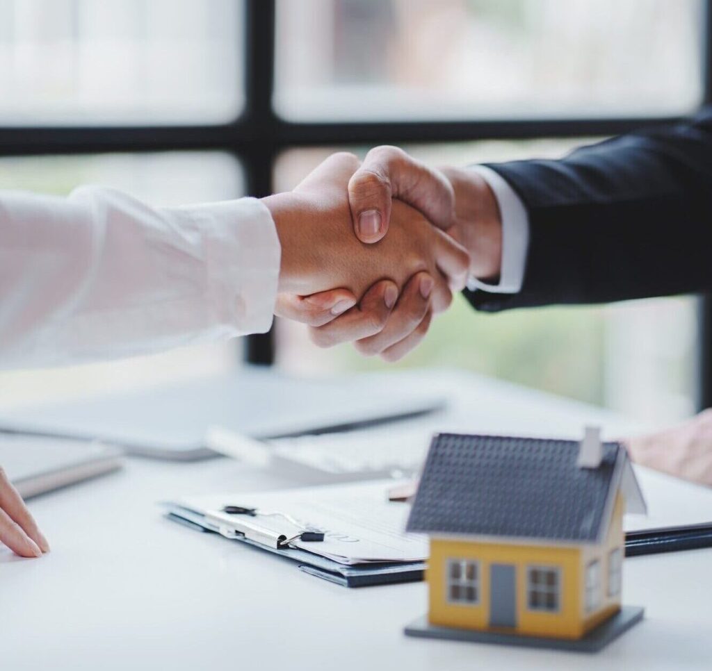Handshake real estate agents deliver sample homes to customers. mortgage loan agreement Make a contr