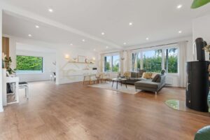 Geräumiges Wohnzimmer mit großen Fenstern