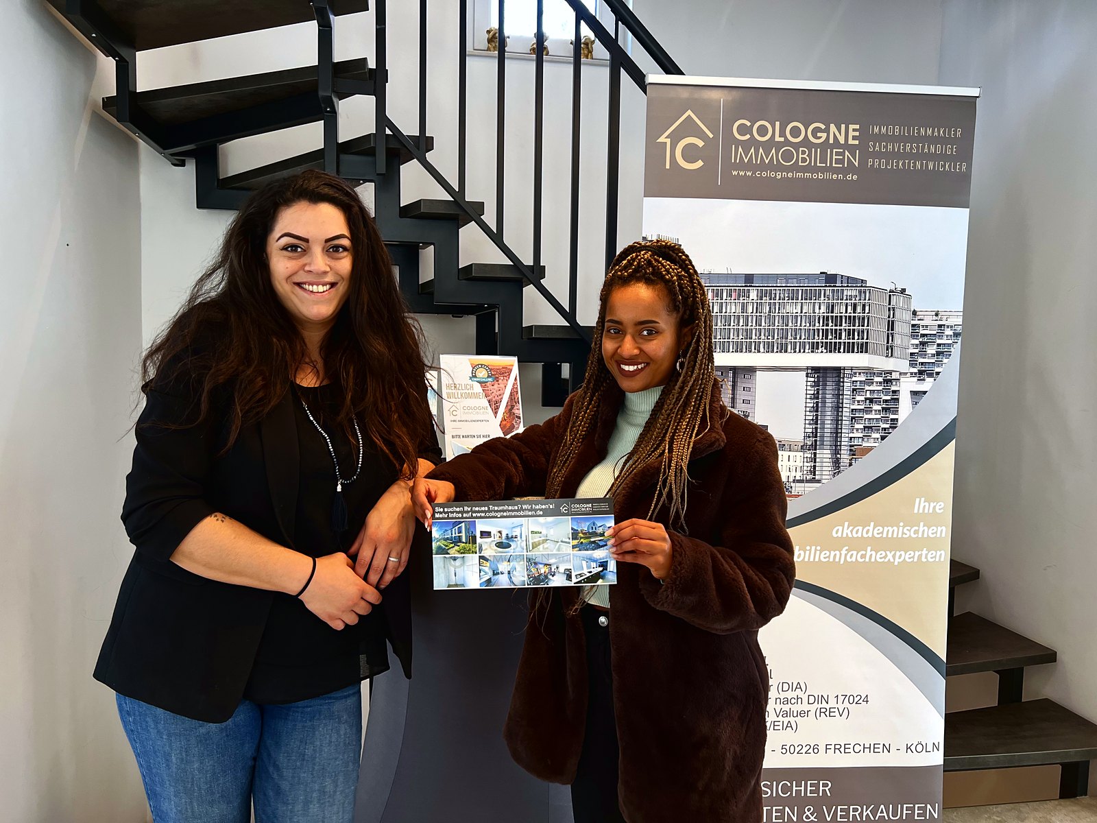 Zwei Mitarbeiterinnen von COLOGNE IMMOBILIEN mit Projektunterlagen im Beratungsraum.