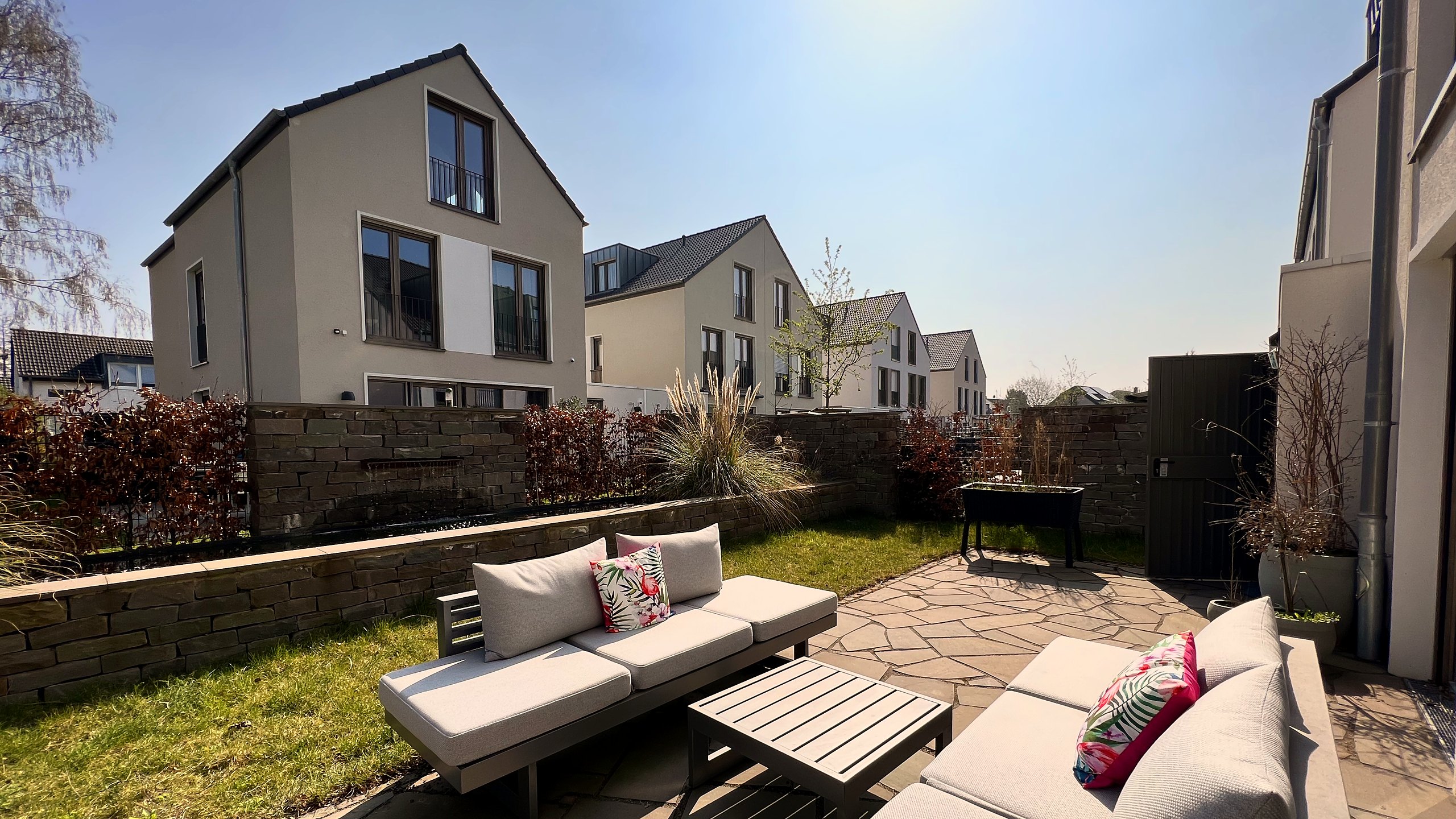 Blick von einer Terrasse auf die fertiggestellte Häuserzeile der Zündorfer Stadtgärten in Köln-Porz-Zündorf.