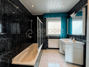 Badezimmer mit Fenster, Badewanne und Handtuchheizkörper