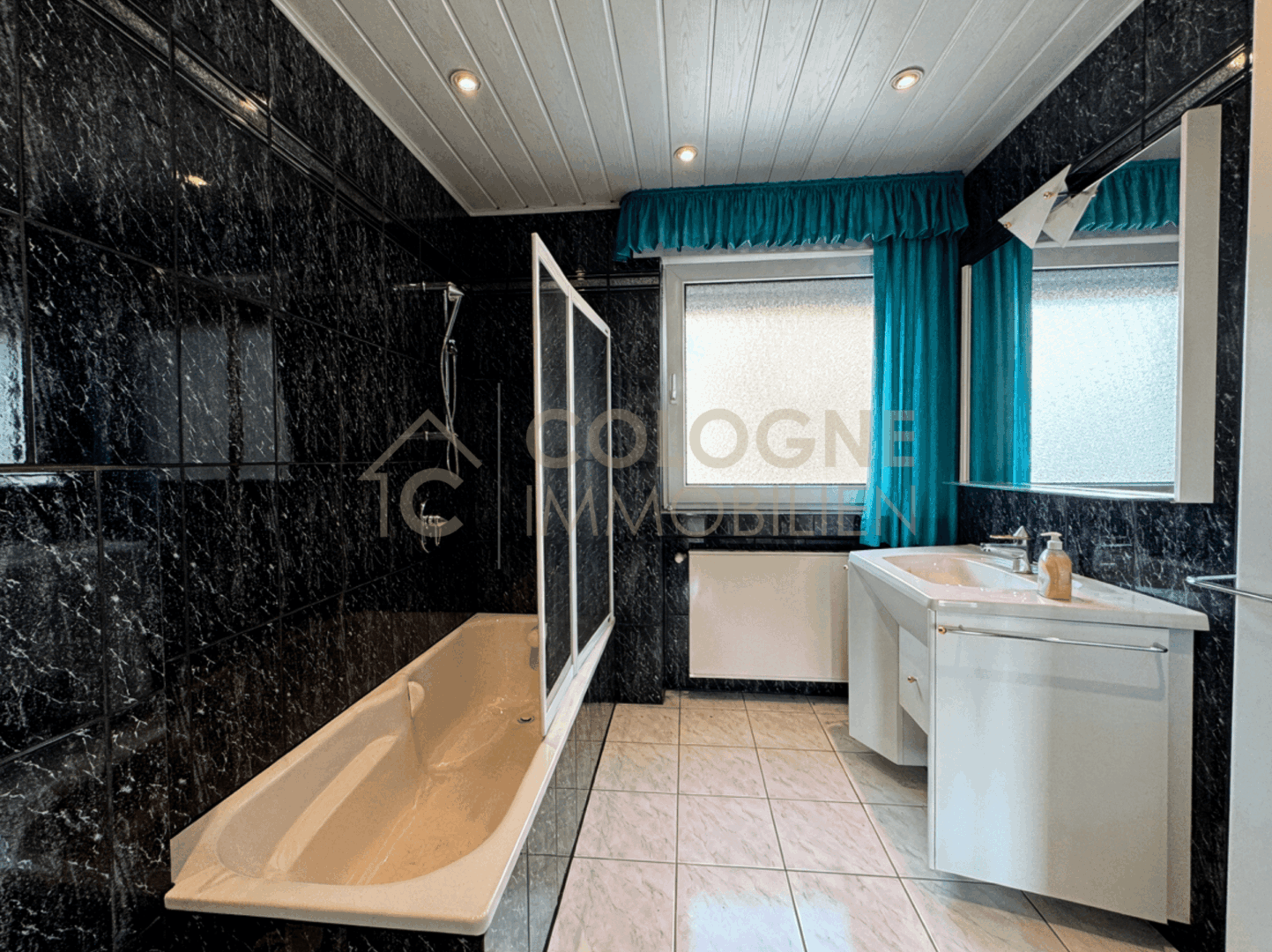 Badezimmer mit Fenster, Badewanne und Handtuchheizkörper