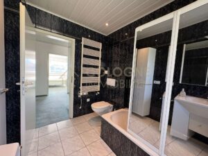 Badezimmer mit Fenster, Badewanne und Handtuchheizkörper