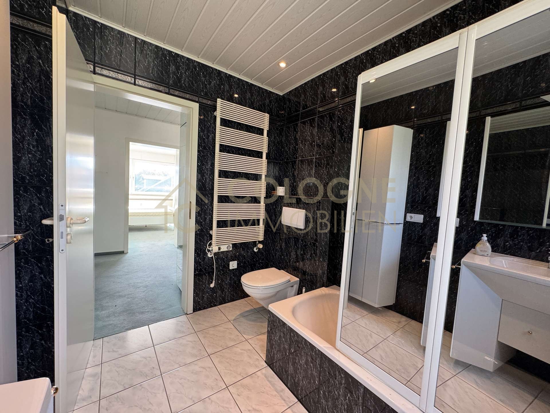 Badezimmer mit Fenster, Badewanne und Handtuchheizkörper